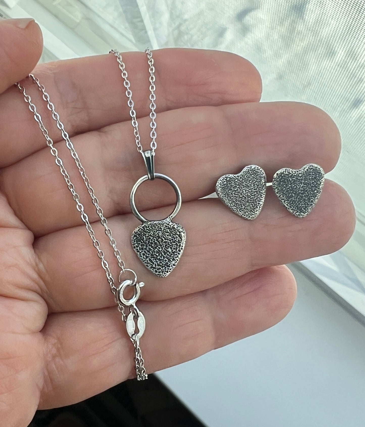 silver jewelry set on hand
