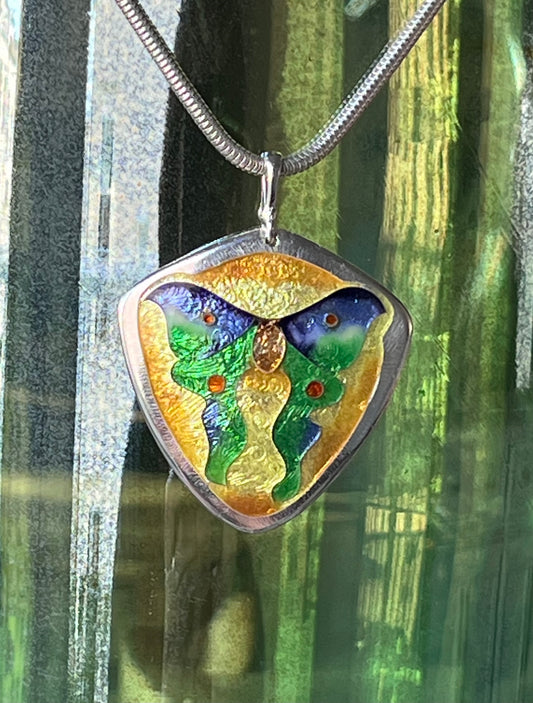 Decorative pendant with a colorful design on a green leafy background