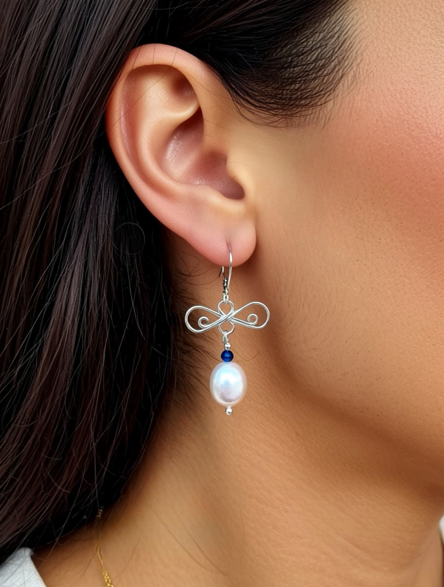 silver and pearl earrings on a model