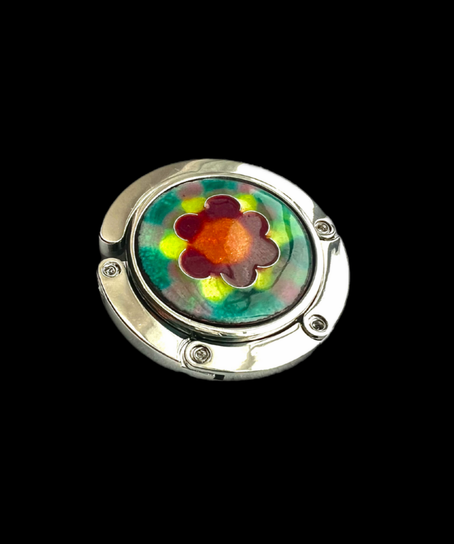 Round metallic object with a colorful flower design on a black background