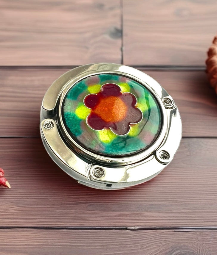 Round decorative item with a colorful flower design on a wooden surface