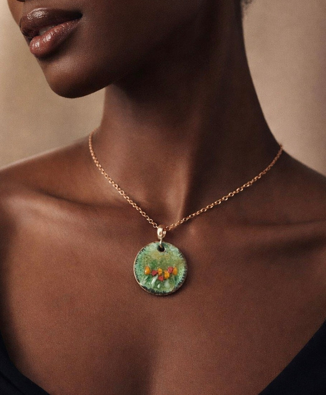 Necklace with a green pendant worn by a model against a neutral background