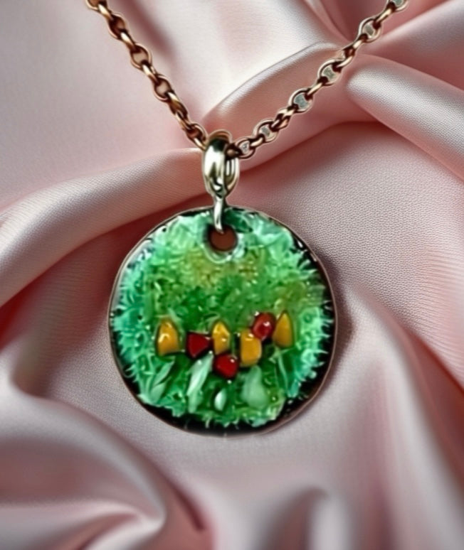 Necklace with a green pendant featuring colorful elements on a pink fabric background