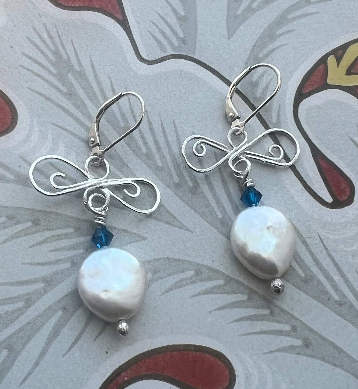 silver and pearl earrings on floral background