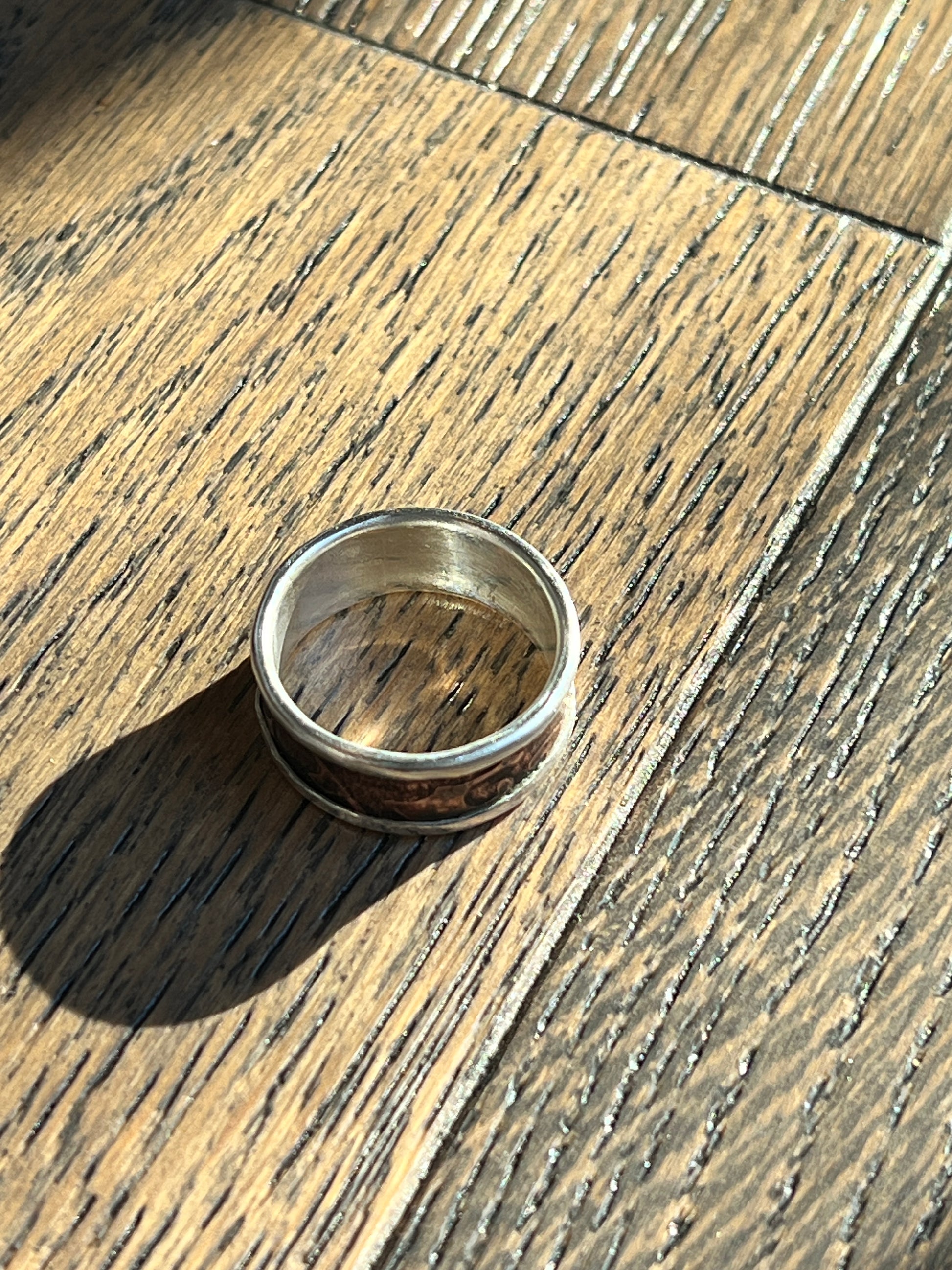 Silver ring on a wooden surface