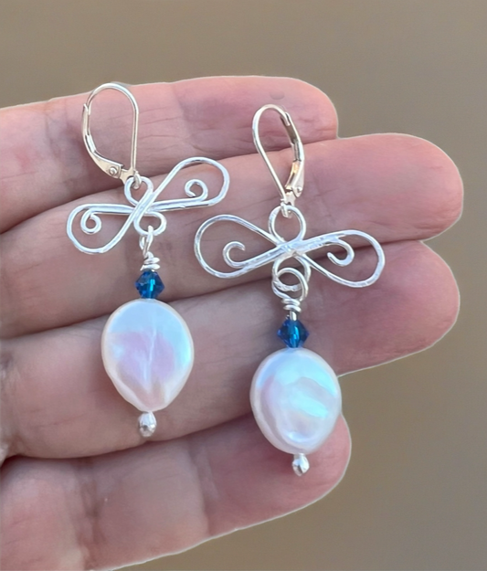 earrings on silver and pearls sitting on a hand