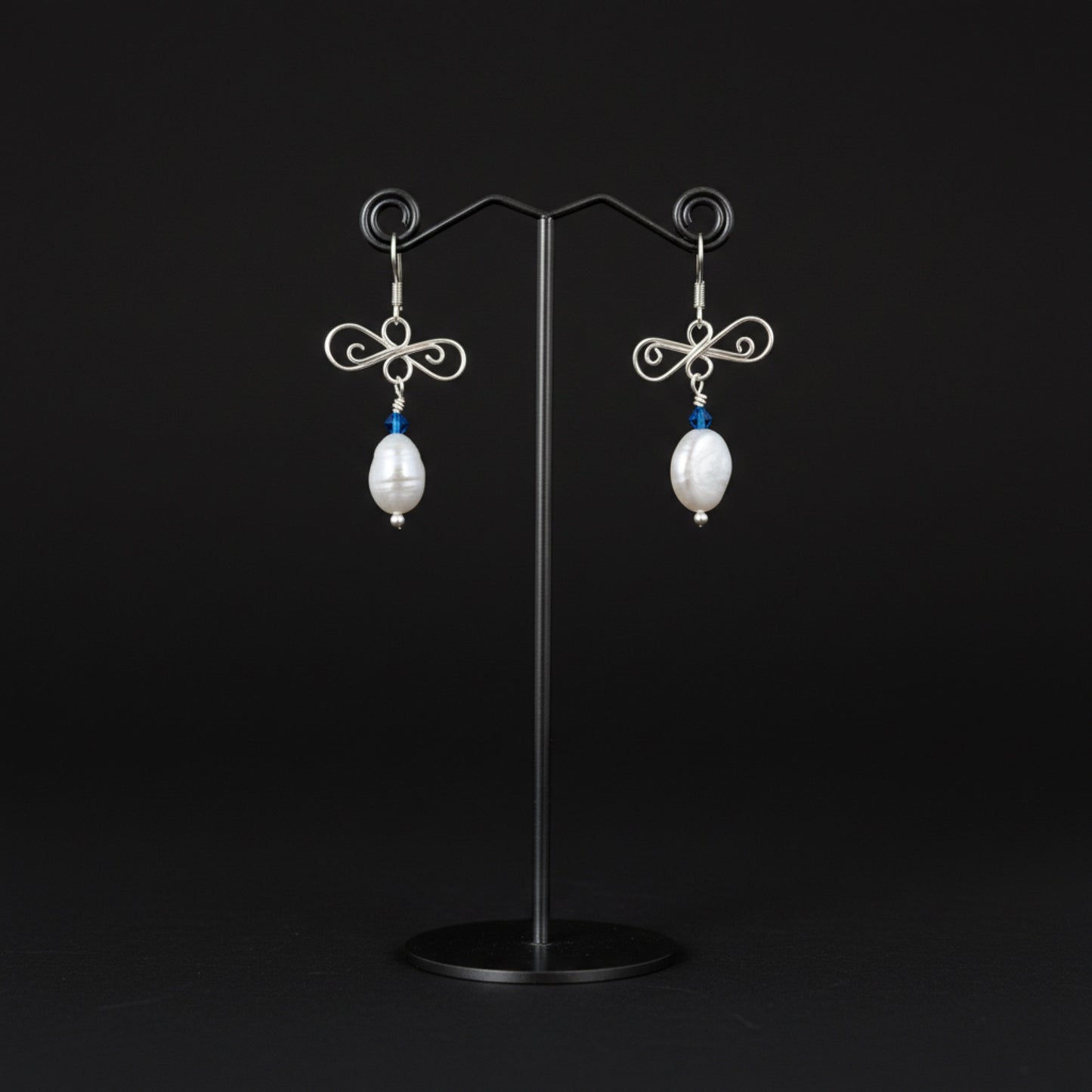 silver and pearl earrings on stand