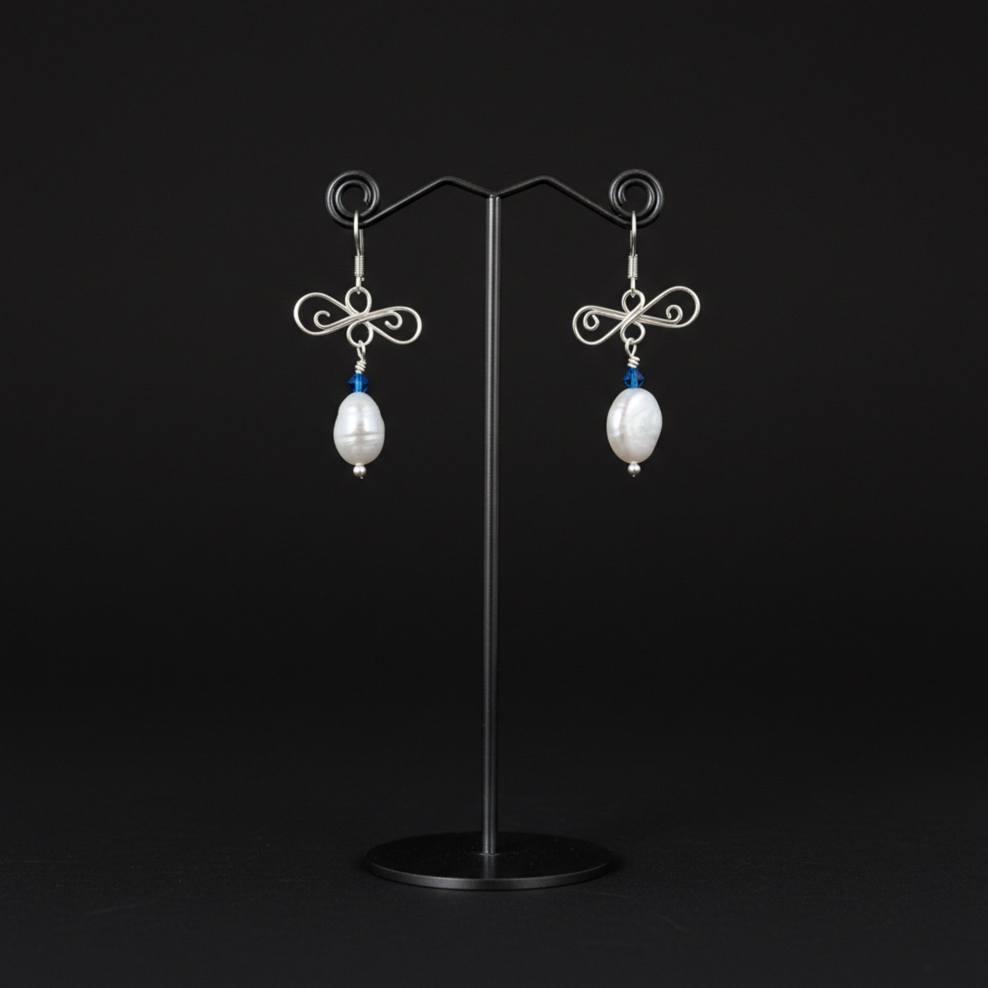 silver and pearl earrings on stand