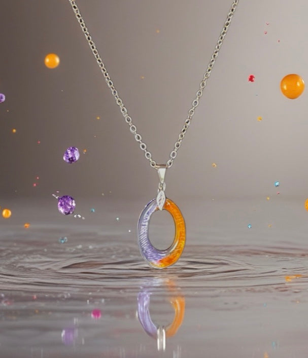 Necklace with a multicolored pendant on a reflective surface with colorful bubbles in the background