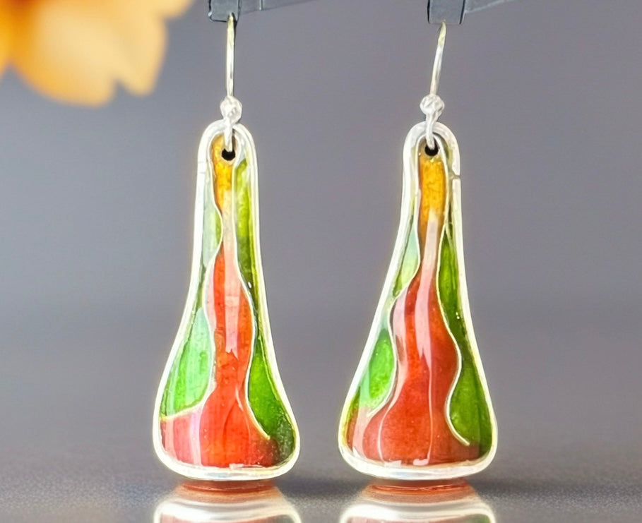 Pair of teardrop-shaped earrings with green and orange design on a gray background