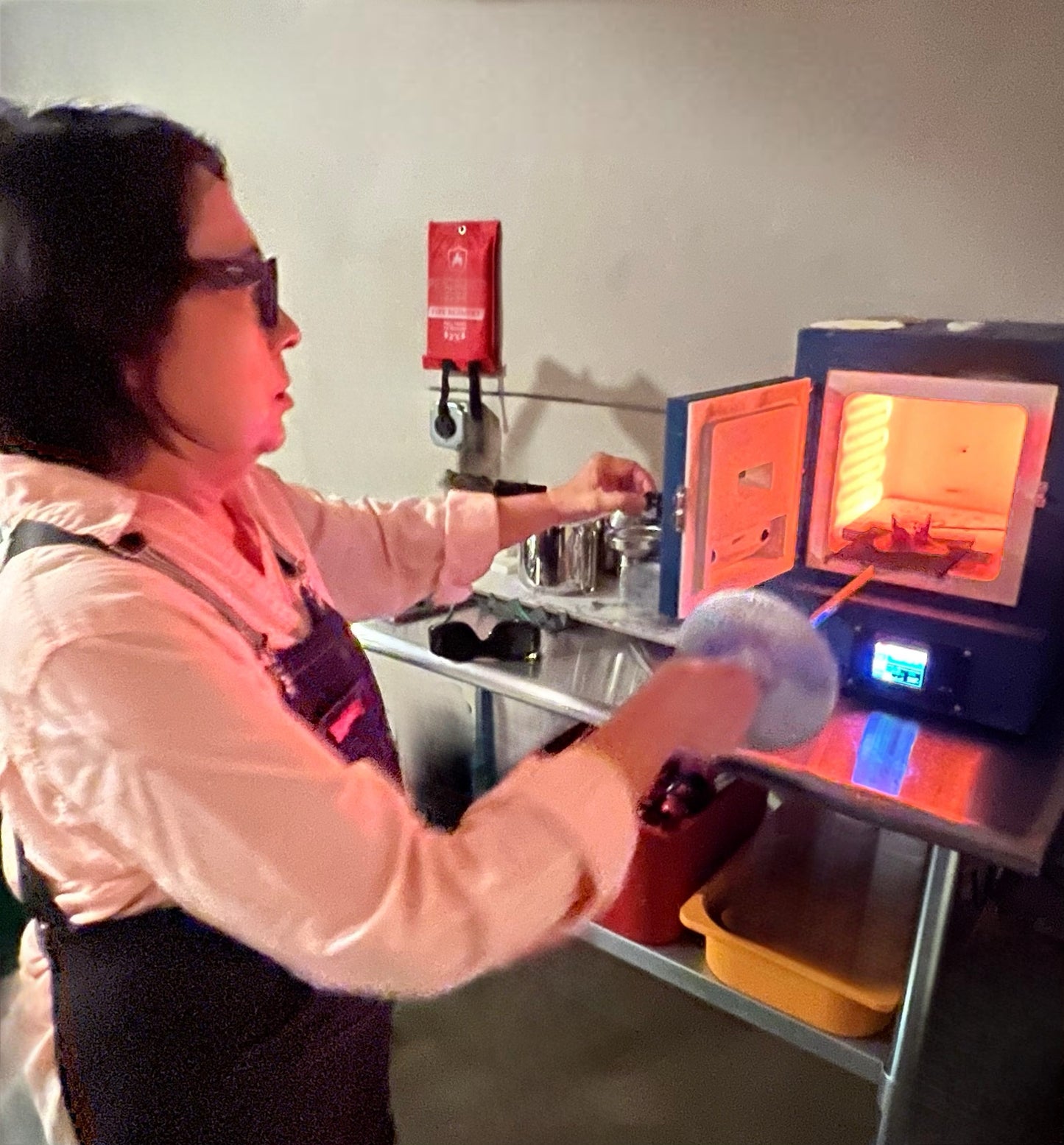 Person working with a furnace in a workshop setting