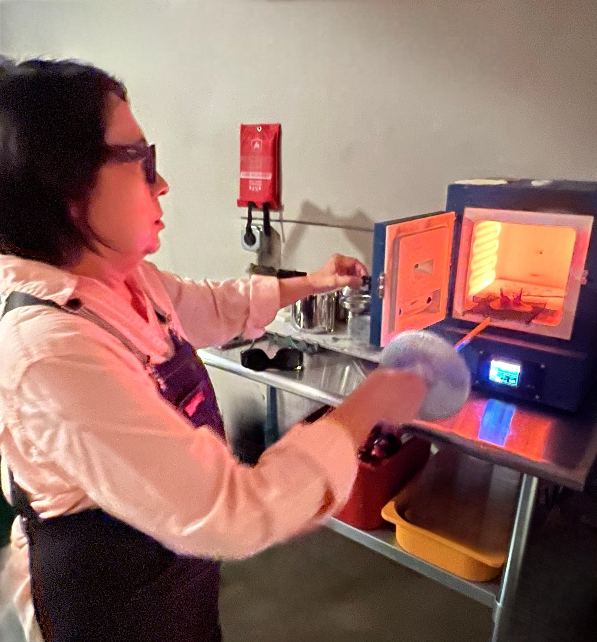 Person working with a furnace in a workshop setting
