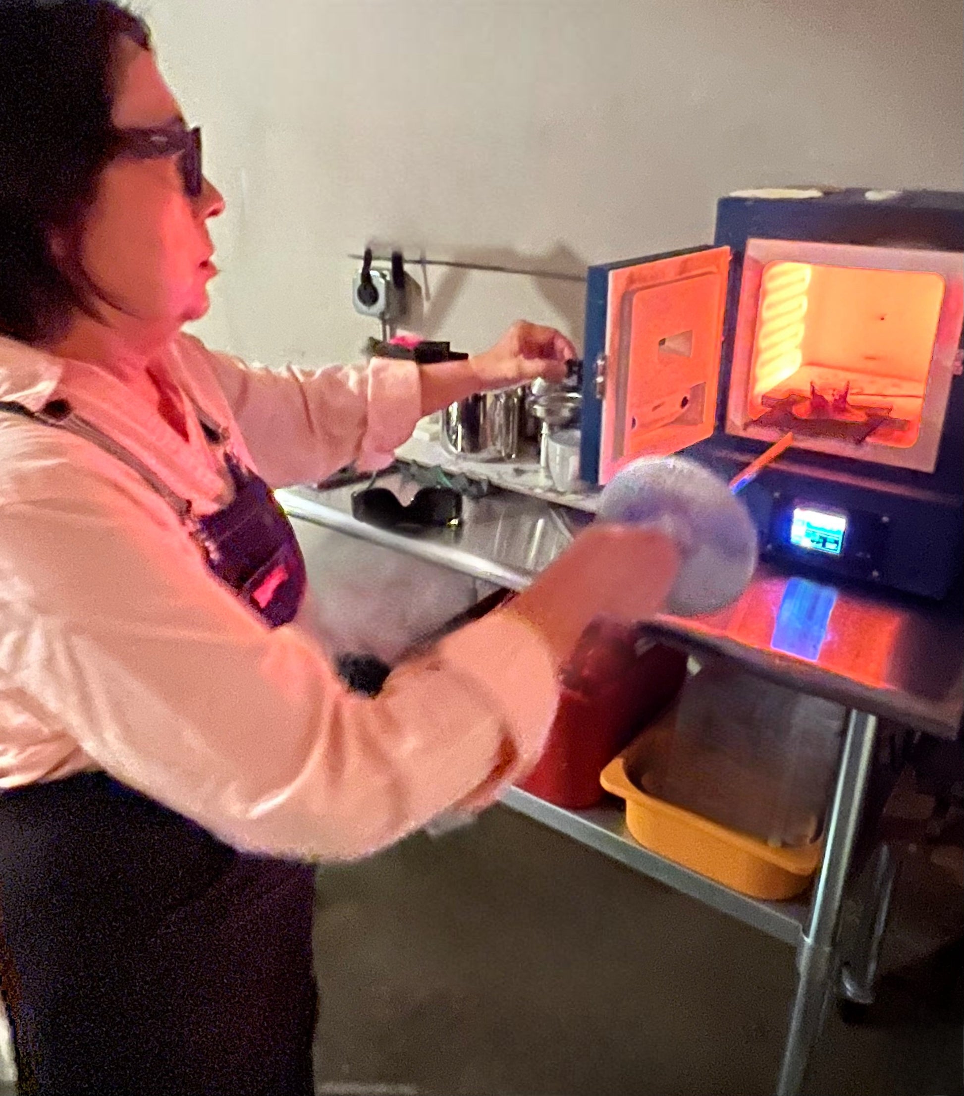 person putting an object on a kiln