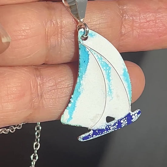 Hand holding sailing boat pendant
